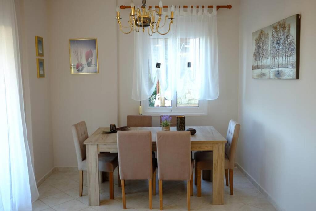 a dining room with a wooden table and chairs at Petra's House in Polychrono