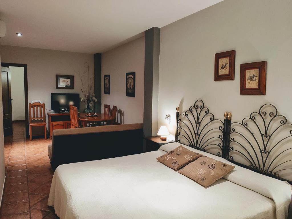ein Schlafzimmer mit einem Bett und ein Wohnzimmer in der Unterkunft La Garzona in Losar de la Vera