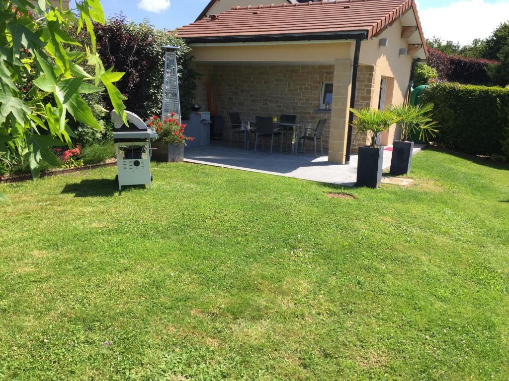 un cortile con un bidone dell'immondizia nell'erba di Studio à la campagne a Montcornet