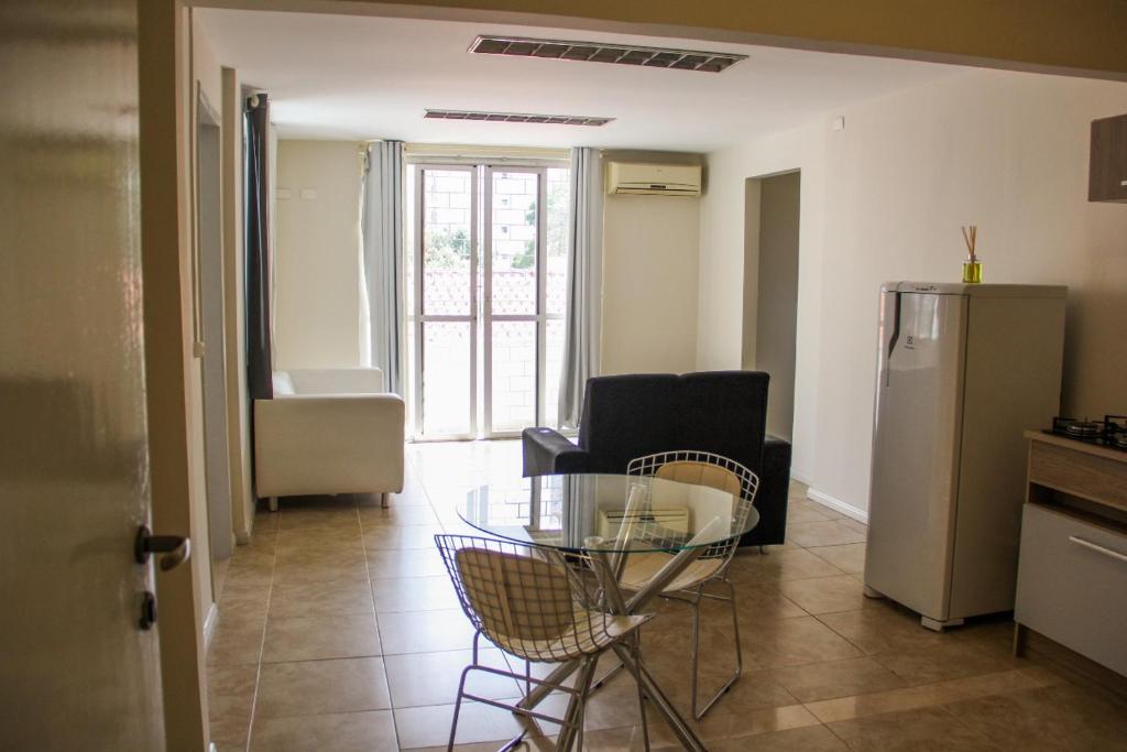 een woonkamer met een glazen tafel en stoelen bij Juveve Loft Apartment in Curitiba