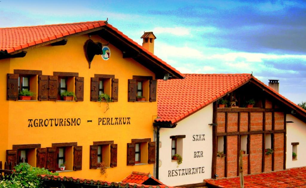 a large yellow building with a red roof at Perlakua Saka in Deba