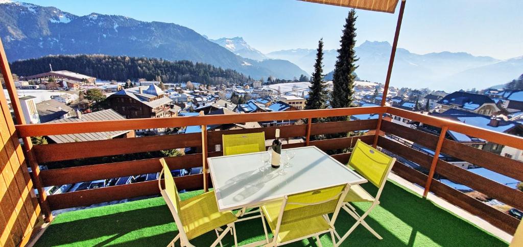 a white table and chairs on a balcony with mountains at Perle de Leysin in Leysin