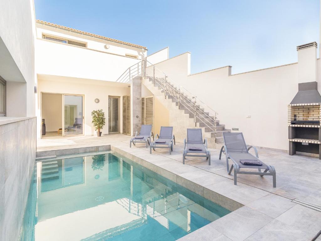 una casa con piscina con sedie e scale di Villa margalida a Sa Pobla