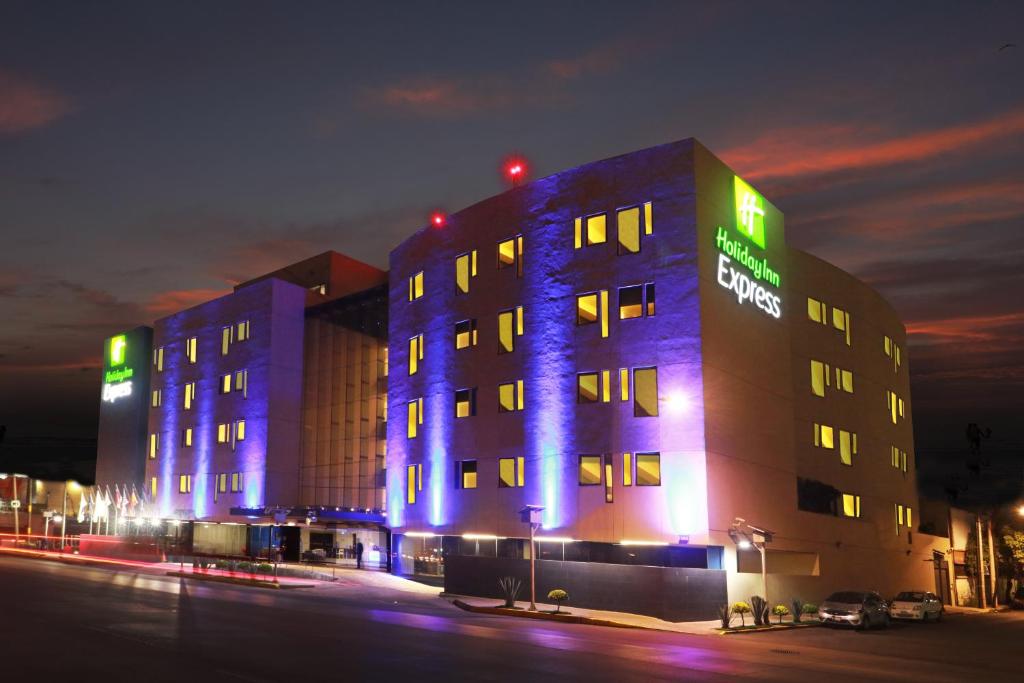 um edifício com luzes azuis na lateral em Holiday Inn Express Mexico Aeropuerto, an IHG Hotel em Cidade do México
