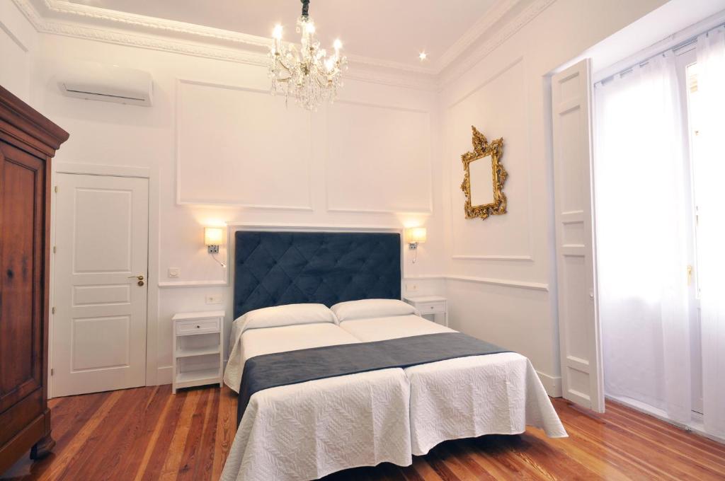 a bedroom with a large bed with a blue headboard at Rua Suites Boutique in Salamanca