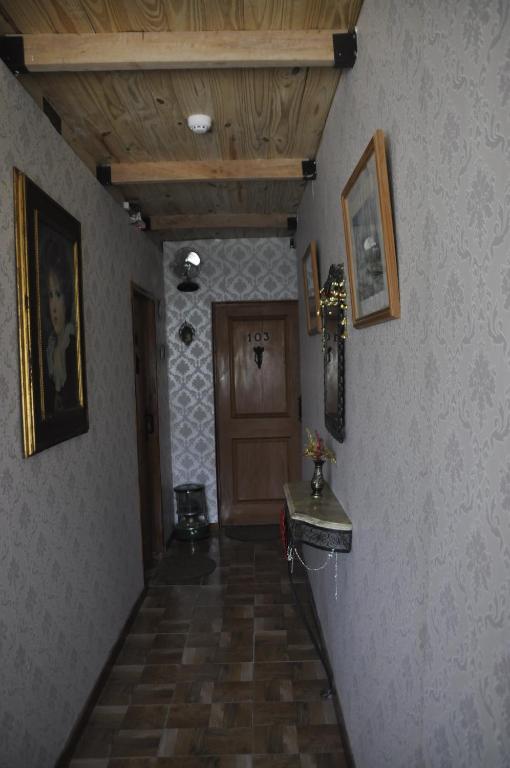 a hallway with a wooden door and a stairway with a hallwayngthngthngth at Posada La Pausa in Miramar