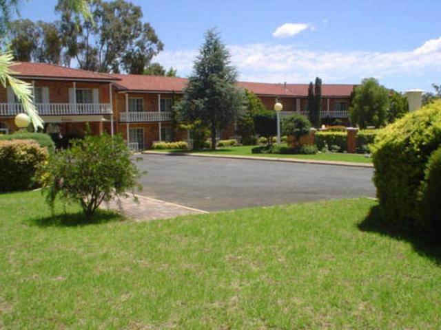 a parking lot in front of a large building at Coachmans Rest Motor Lodge in Coonabarabran