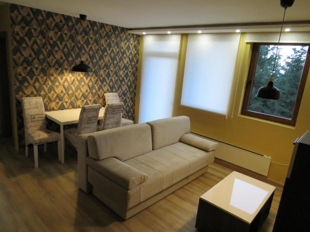 a living room with a couch and a table at Apartman Žuta dunja - Sunčani breg in Kopaonik