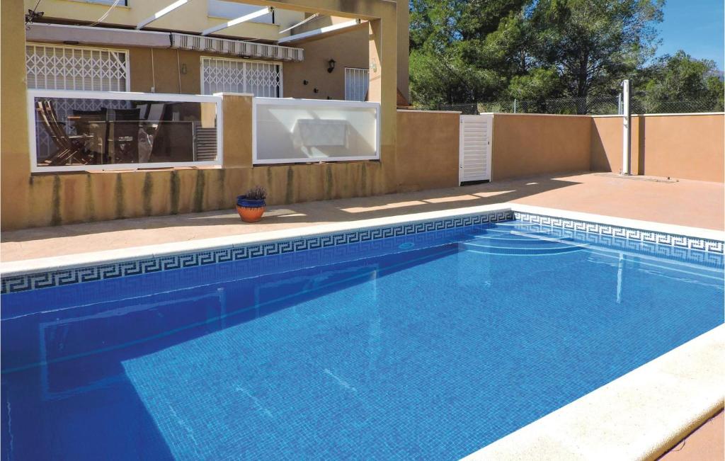 a large blue swimming pool in a backyard at Amazing Home In F-43893 Miami Platja With 2 Bedrooms, Outdoor Swimming Pool And Swimming Pool in Les Planes del Rei