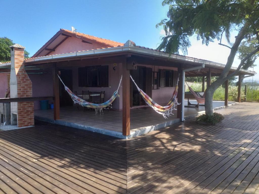 a house with hammocks on the porch at Casa Lagoa e Praia Rosa in Praia do Rosa