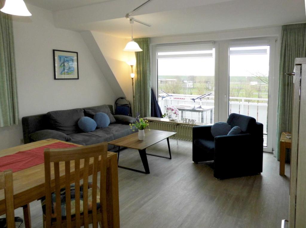 uma sala de estar com um sofá e uma mesa em Appartement Buesum GT33-4 em Büsum