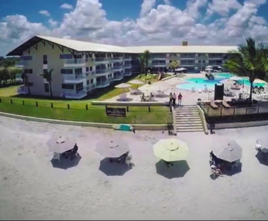 a view of a resort with a pool and a building at Muro Alto Suites - Marupiara in Porto De Galinhas