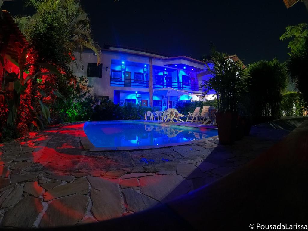 una casa con piscina por la noche en Pousada Larissa, en Paraty