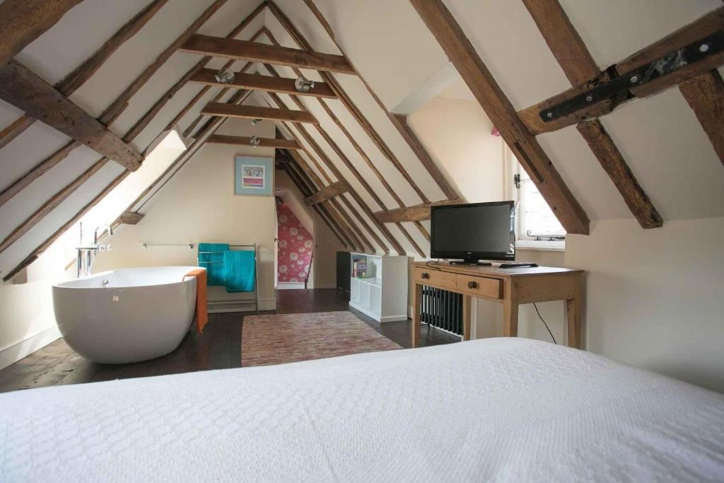 sypialnia z białym łóżkiem i telewizorem w obiekcie Medieval Town House - Walled Garden Sleeps 8 w mieście Rye