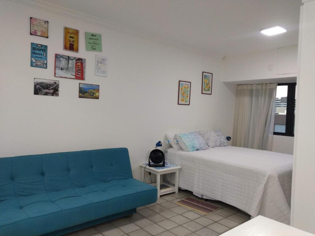 sypialnia z łóżkiem i niebieską kanapą w obiekcie Studio perto do Cristo carnaval circuito ondina w mieście Salvador