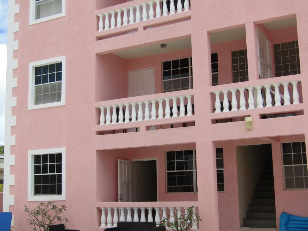 Edificio rosa con balcón en Half Moon Bay, en Christ Church