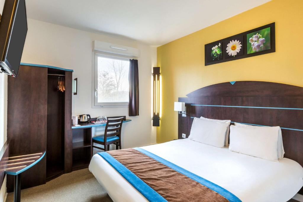 サンタマン・レゾーにあるSure Hotel by Best Western Saint-Amand-Les-Eauxのベッドとデスクが備わるホテルルームです。
