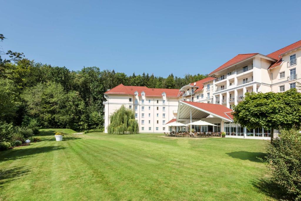 un grand bâtiment avec une grande pelouse devant lui dans l'établissement Best Western Plus Parkhotel Maximilian Ottobeuren, à Ottobeuren