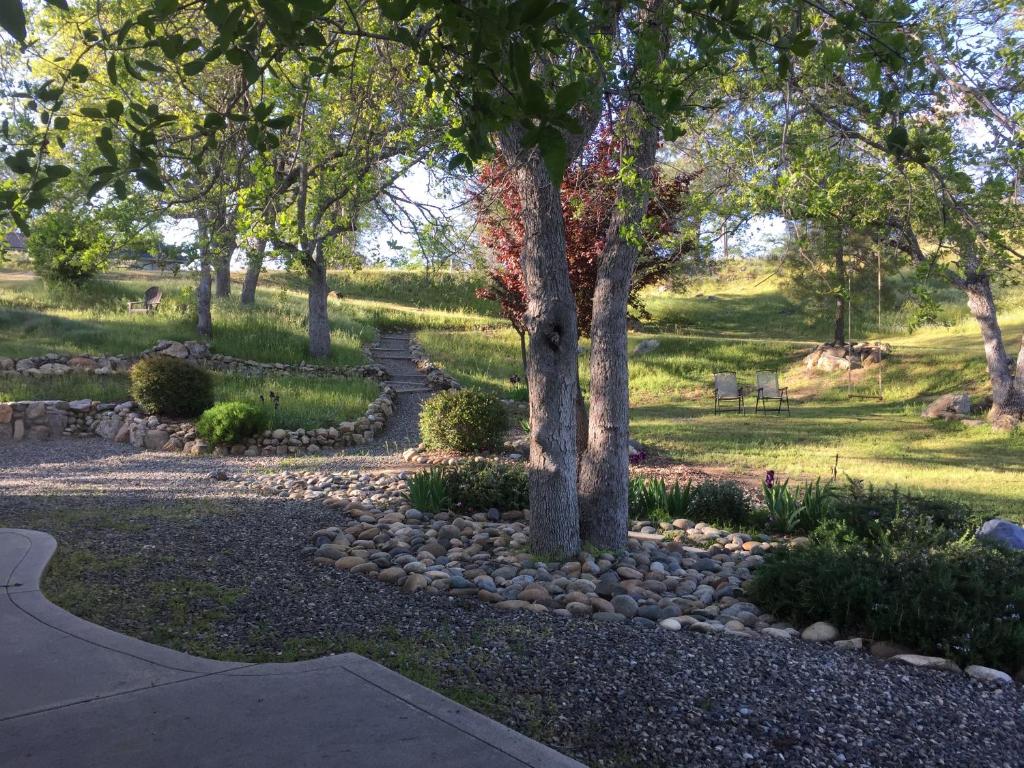 a garden with rocks and trees and a path at Oak Retreat by Yosemite National Park in Coarsegold