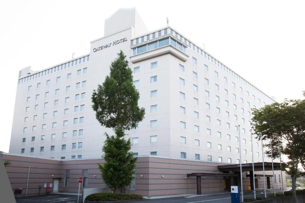 un bâtiment blanc avec un arbre devant lui dans l'établissement Narita Gateway Hotel, à Narita