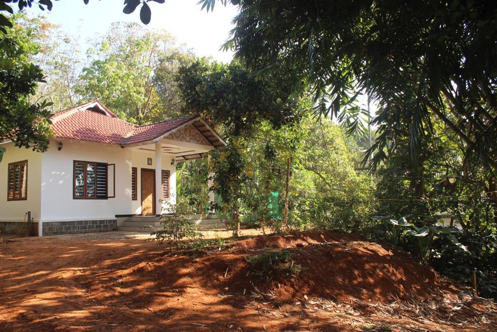 a house with a dirt yard in front of it at Wayanad Days in Mananthavady