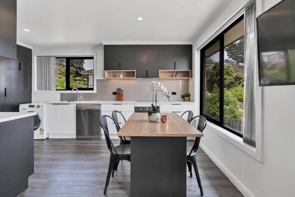 a kitchen with a table, chairs, and a window at Youngtown Executive Apartments - Host RNR Apartments in Launceston