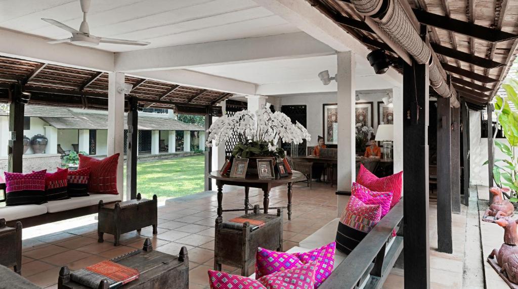 a living room with a table and chairs at Tamarind Village in Chiang Mai
