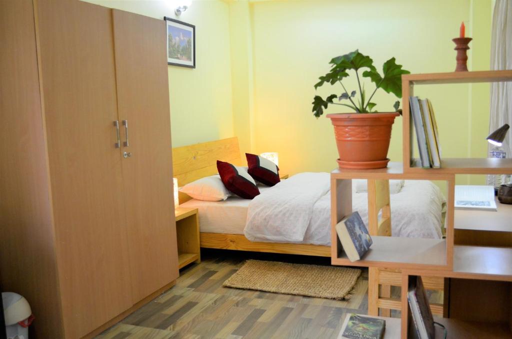 1 dormitorio con 1 cama y una maceta en Tanani Newa Home Arnnapurna, en Pātan