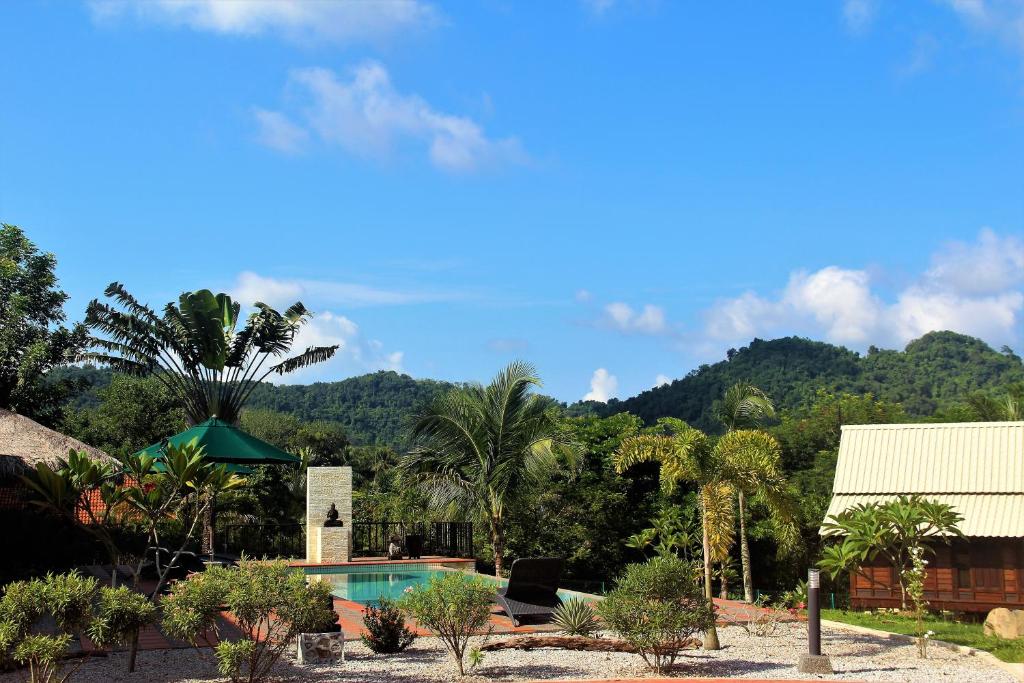 Villa Kelapa Langkawi في كواه: منتجع فيه مسبح وجبال في الخلف