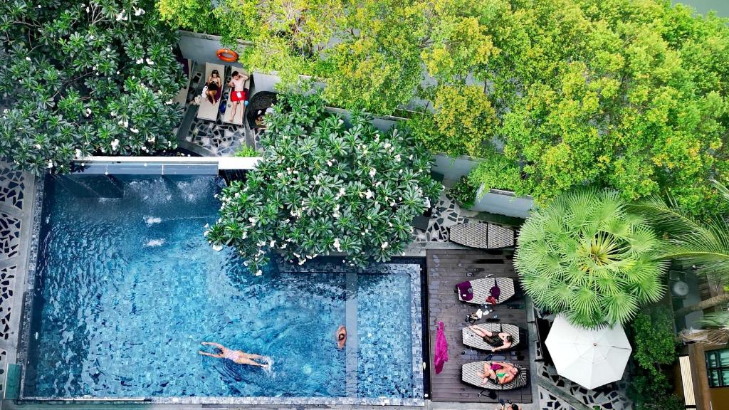 una vista aérea de una piscina con personas nadando en Mazi Design Hotel by Kalima - SHA Plus en Patong