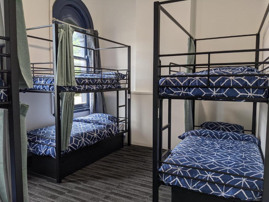 Postel nebo postele na pokoji v ubytování Queen Victoria Hostel