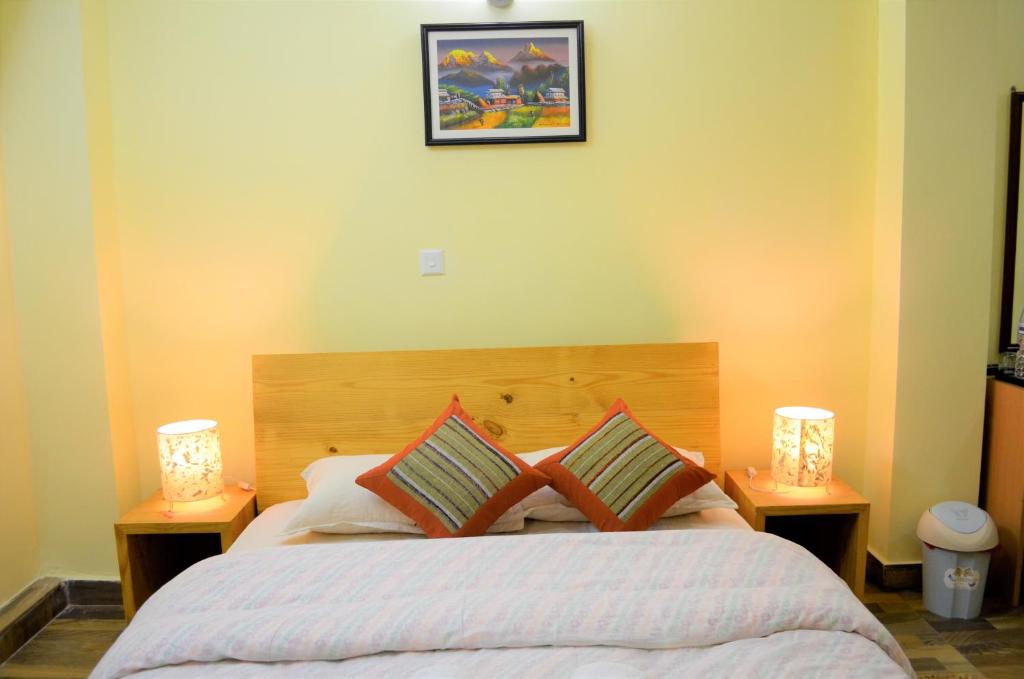 1 dormitorio con 1 cama grande y 2 lámparas en Tanani Newa Home -Dhaulagiri, en Pātan