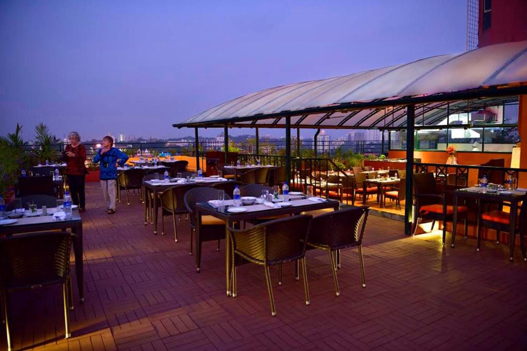 a restaurant with tables and chairs on a roof at The South Park Hotel in Trivandrum