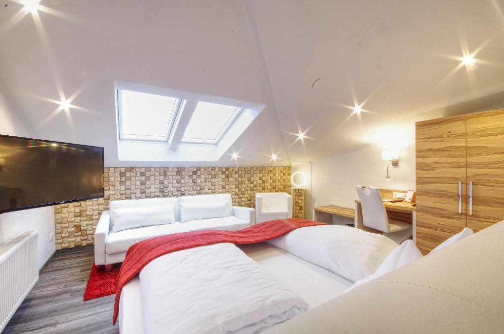 um quarto com 2 camas e uma televisão de ecrã plano em Hotel Jakob em Groß-Umstadt