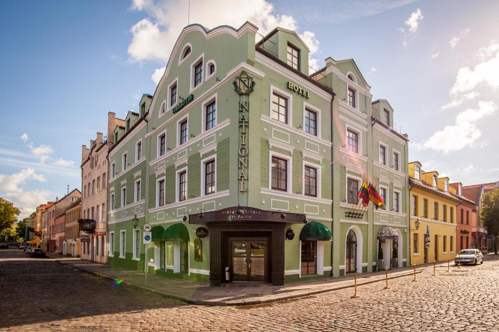 zielony i biały budynek na ulicy w obiekcie National Hotel w Kłajpedzie