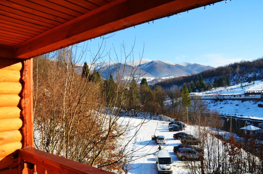 een uitzicht vanuit een cabineraam op een met sneeuw bedekte tuin bij Teremok Guest House in Vyshka