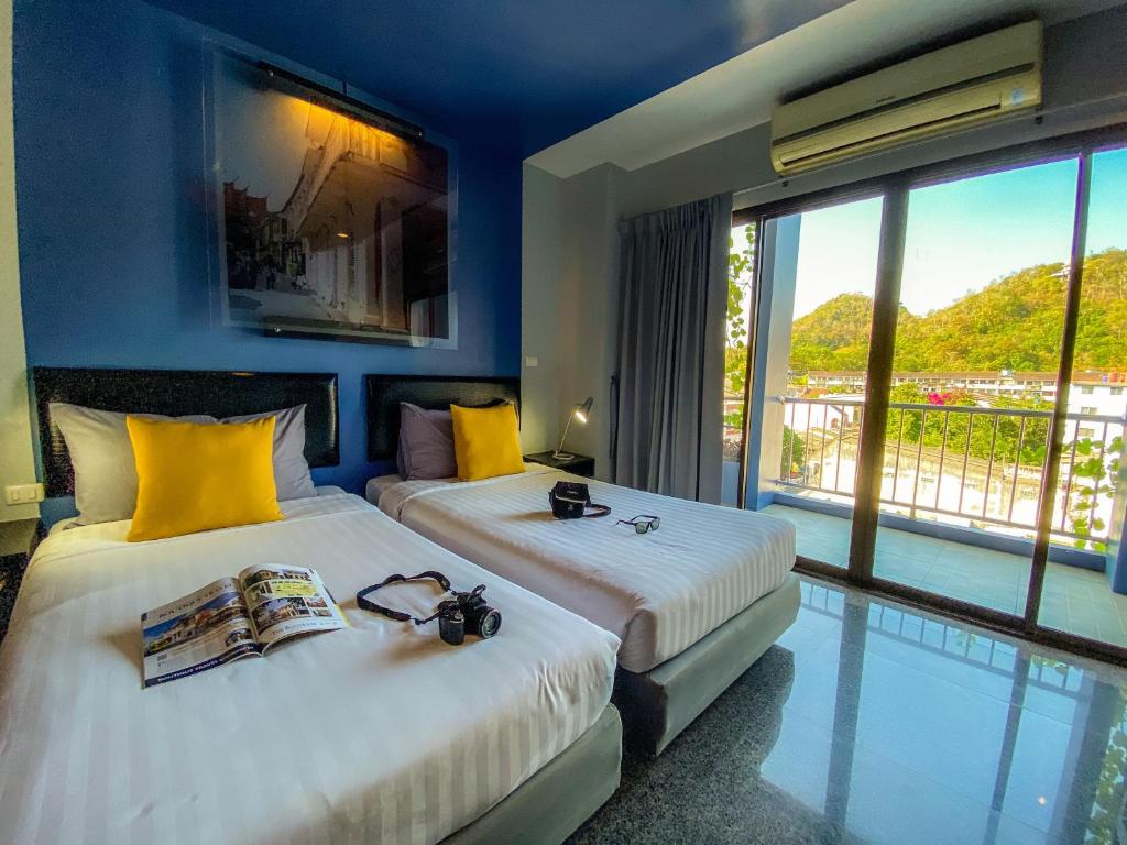 Tempat tidur dalam kamar di Sino Inn Phuket Hotel - SHA Plus