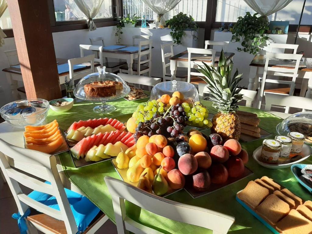 a table with a bunch of fruits and vegetables on it at Hotel La Villa Del Mare in Cagliari
