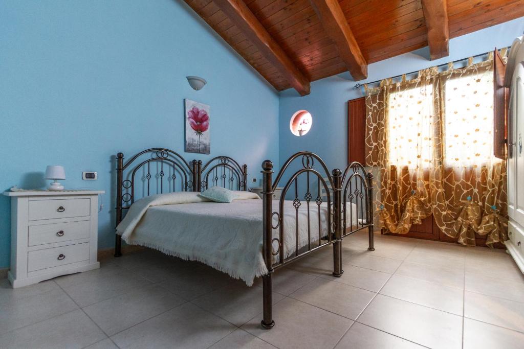 1 dormitorio con cama y pared azul en La Capinera en San Vito