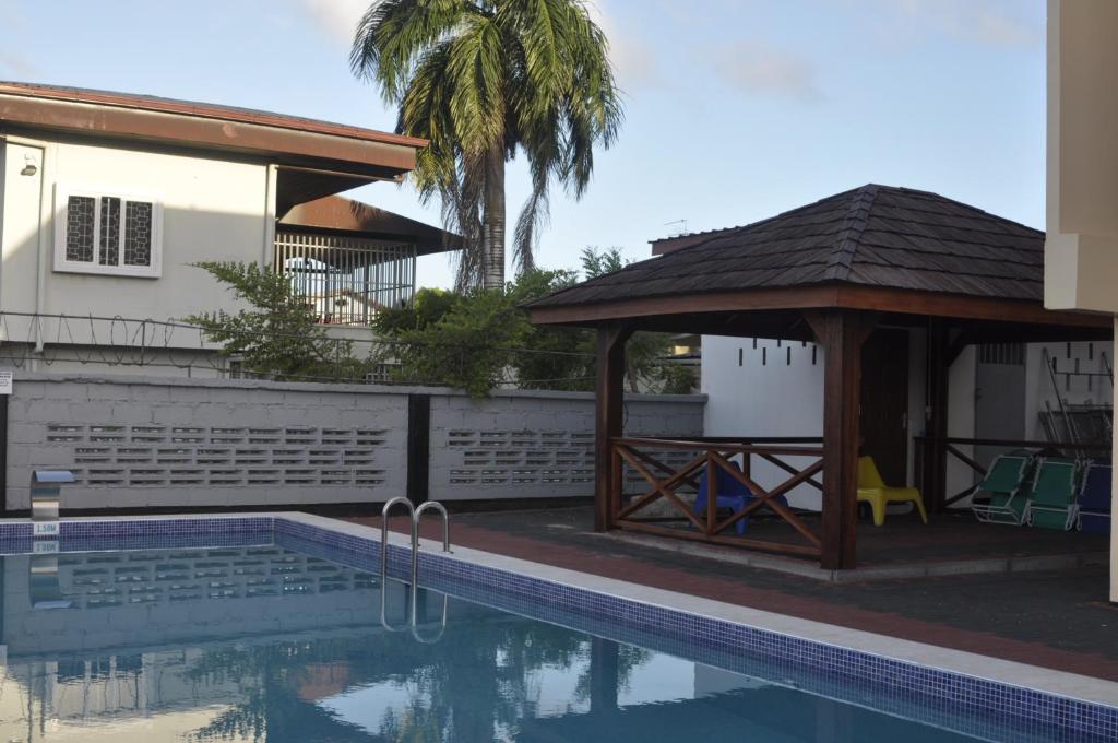 a pool and a gazebo next to a house at Riando appartement Royal Rainville in Paramaribo