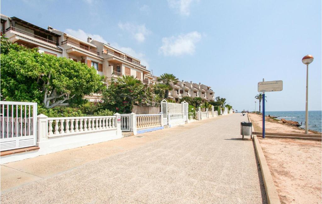 a sidewalk next to a beach with buildings and the ocean at 5 Bedroom Nice Home In Santa Pola in Santa Pola