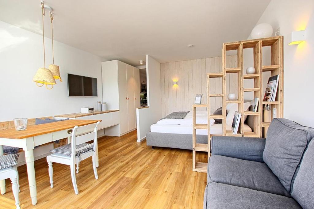 ハイリゲンハーフェンにあるHaus am Binnenseeのリビングルーム(ベッド1台、テーブル、ソファ付)