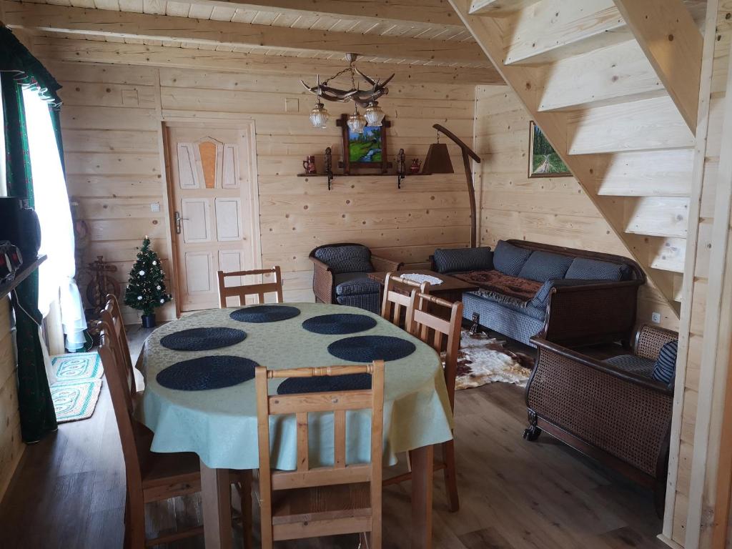 a living room with a table and a couch at Babiogórski Raj in Lipnica Wielka