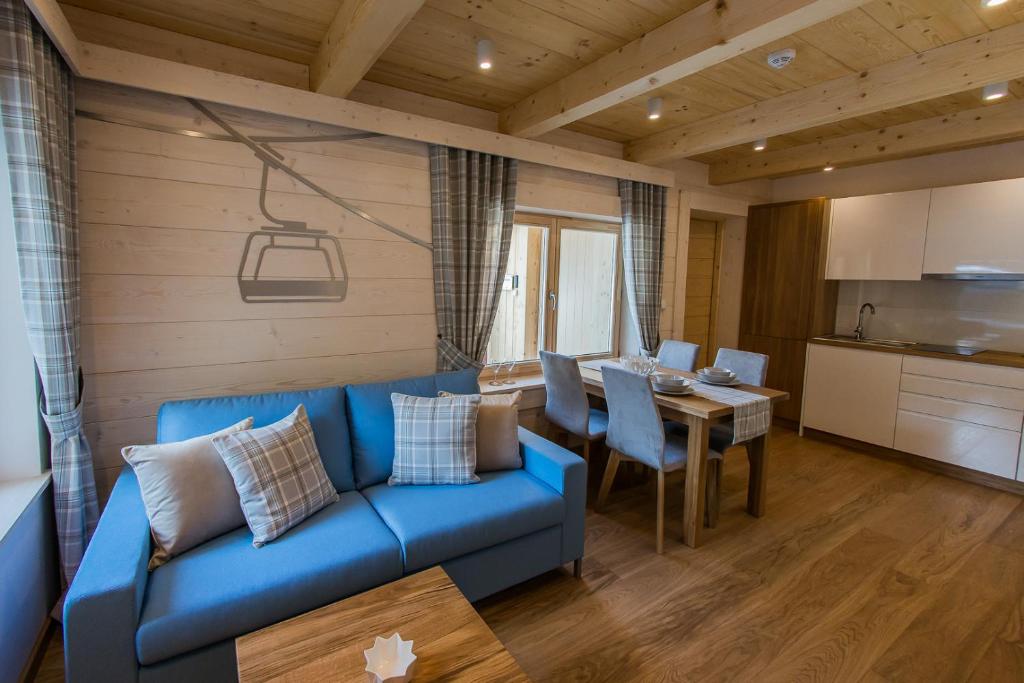 a living room with a blue couch and a table at Apartamenty Kuźnice 13 in Zakopane