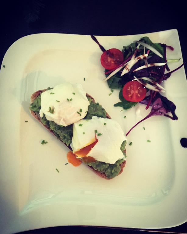 a white plate with a piece of bread with food on it at The Carrick in Portrush