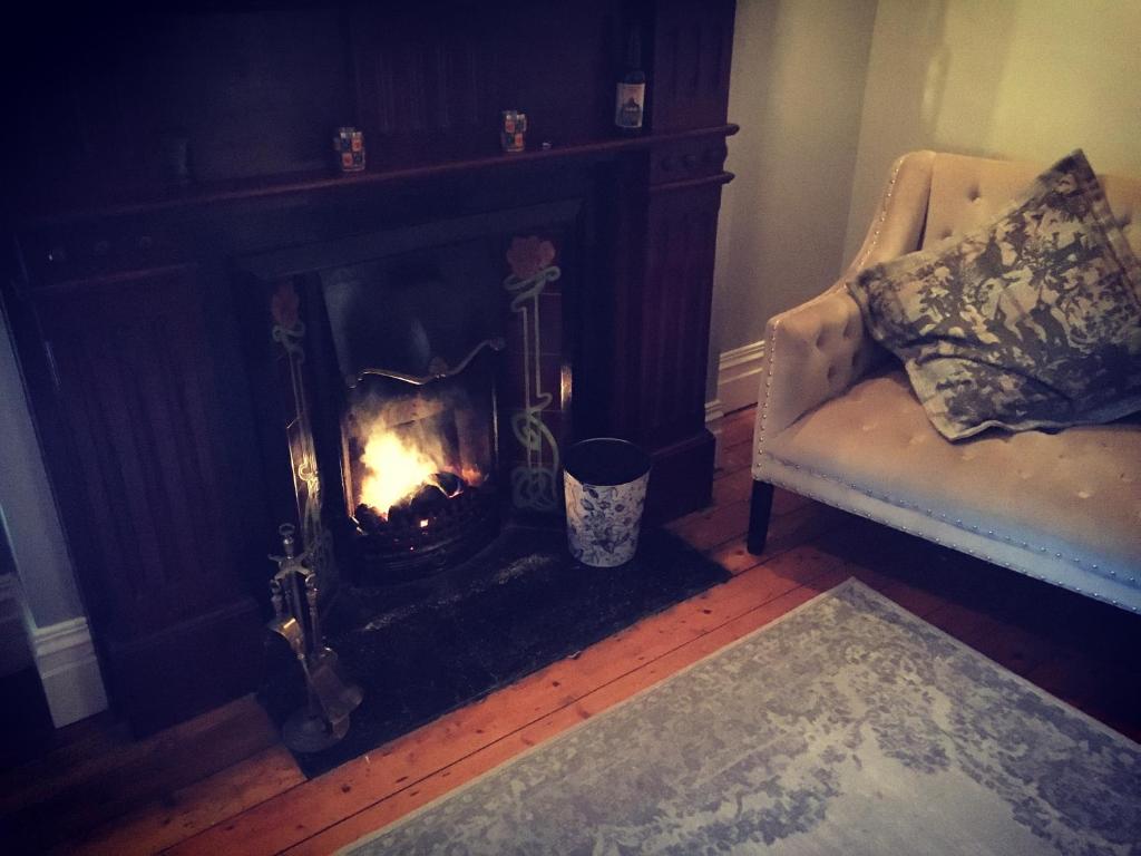 a living room with a fireplace and a chair at The Carrick in Portrush