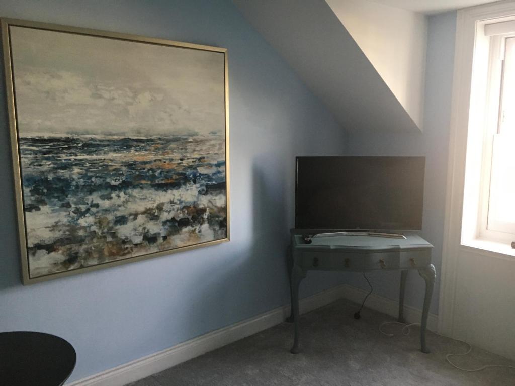 a painting hanging on a wall next to a desk at The Carrick in Portrush