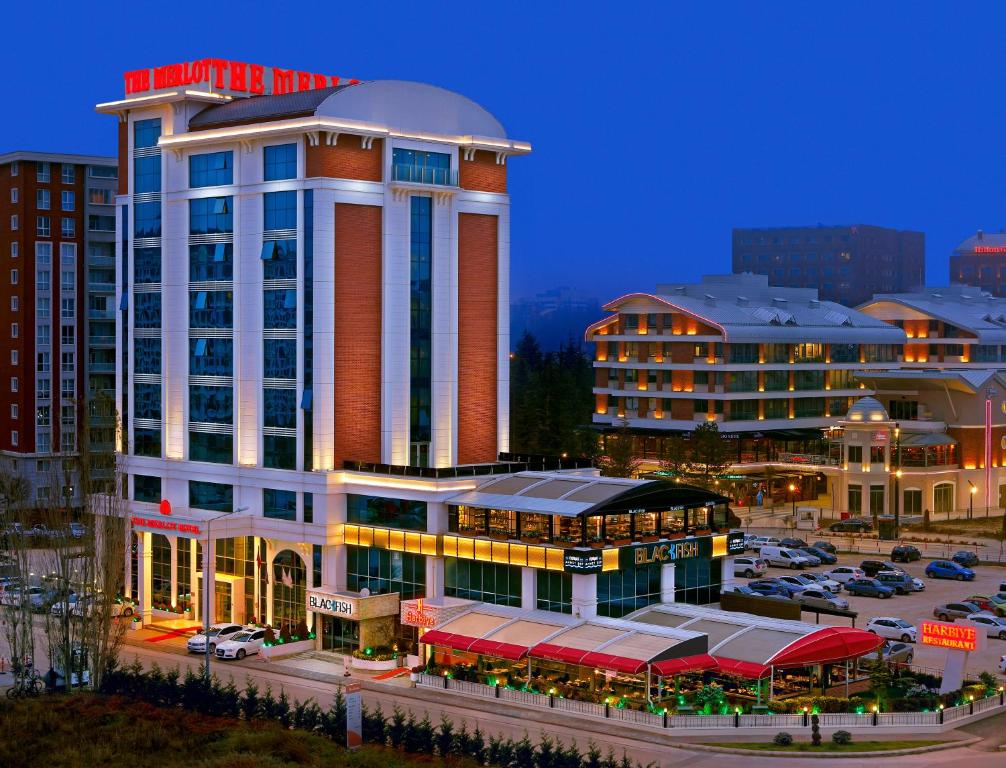 un edificio de hotel con un aparcamiento enfrente en The Merlot Hotel Eskisehir, en Eskisehir