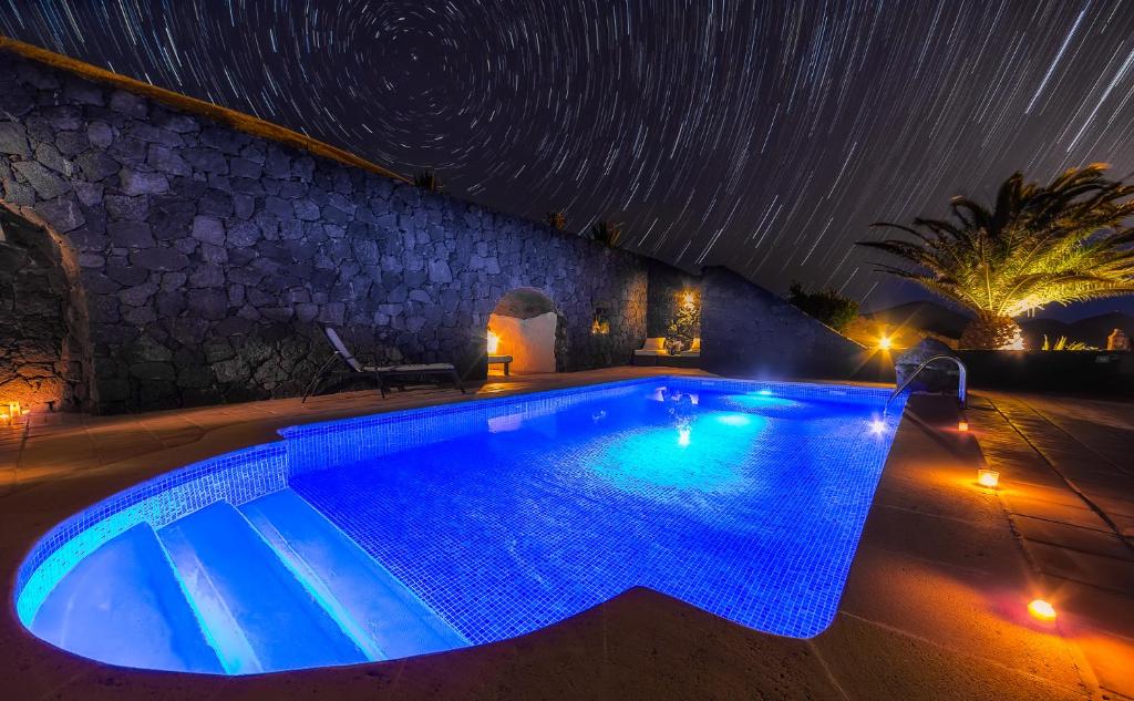 una piscina por la noche con estrellas en el cielo en Casa Gecko, en Tías