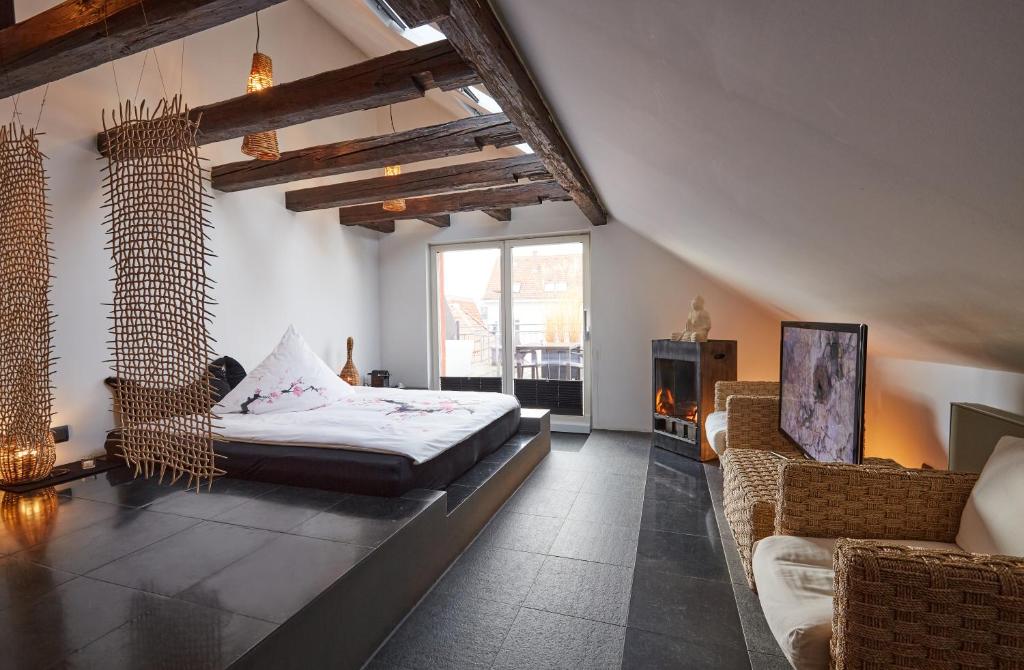 sypialnia z łóżkiem, kanapą i oknem w obiekcie Der Zauberlehrling w Stuttgarcie